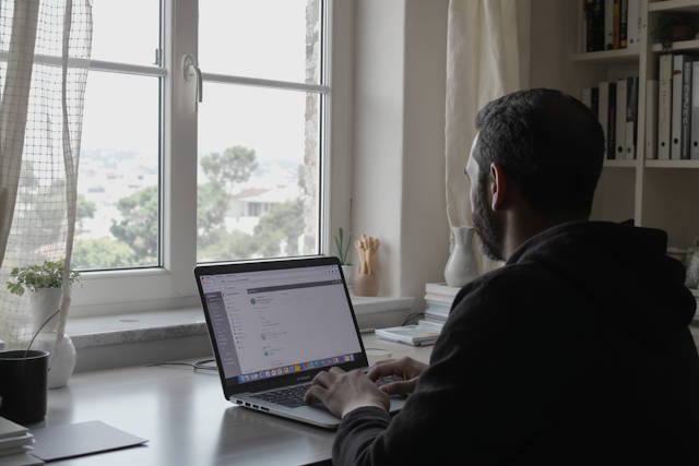 גבר יושב מול מחשב נייד.